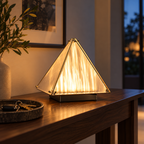 Pyramid ambient desk lamp glowing on an entryway console at dusk