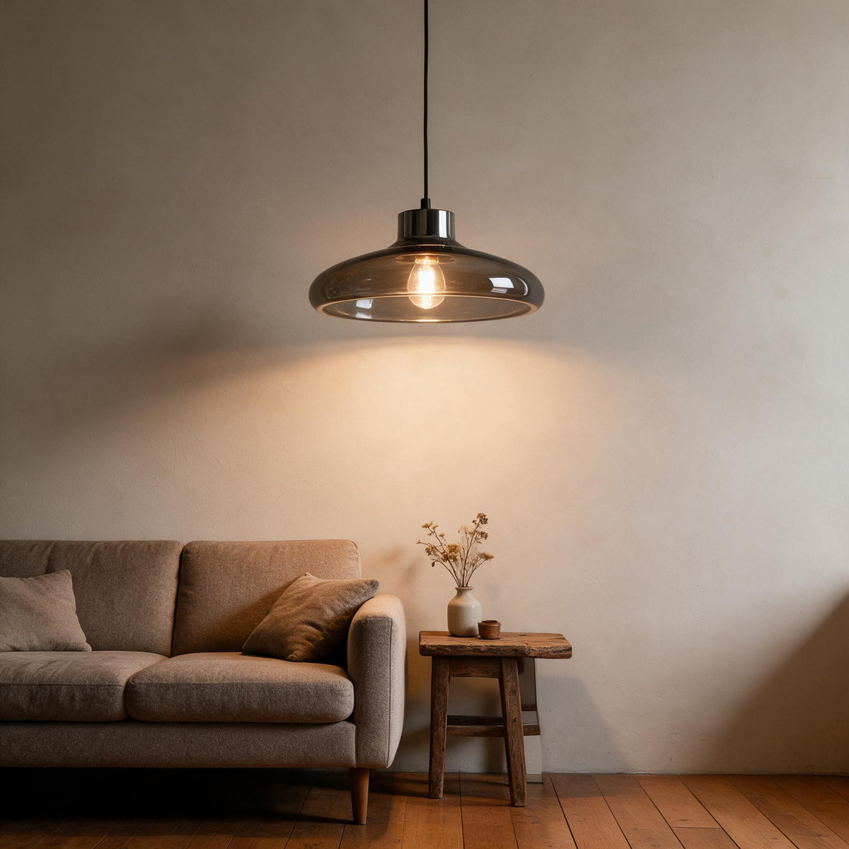 Grey glass pendant light diffusing a soft glow in a living space