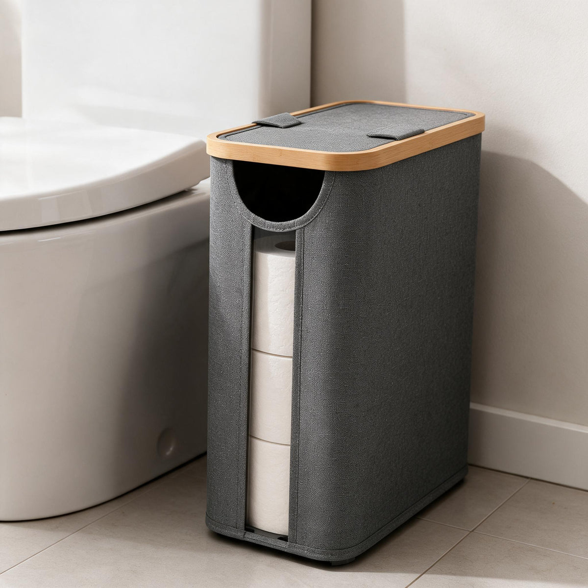 Free-standing toilet paper storage basket filled with rolls next to a toilet.