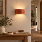 Brown orange French resin wall sconce illuminating a warm hallway