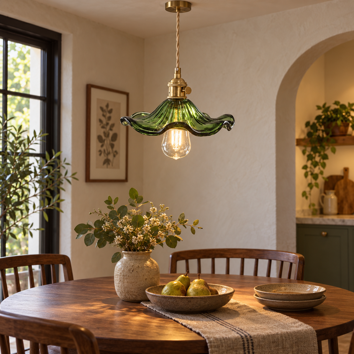 Green glass and antique brass pendant light above a warm modern dining table