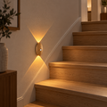 Light wood rechargeable motion sensor stair light illuminating a modern staircase