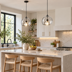 Transparent double-glass pendant lights above a bright kitchen island