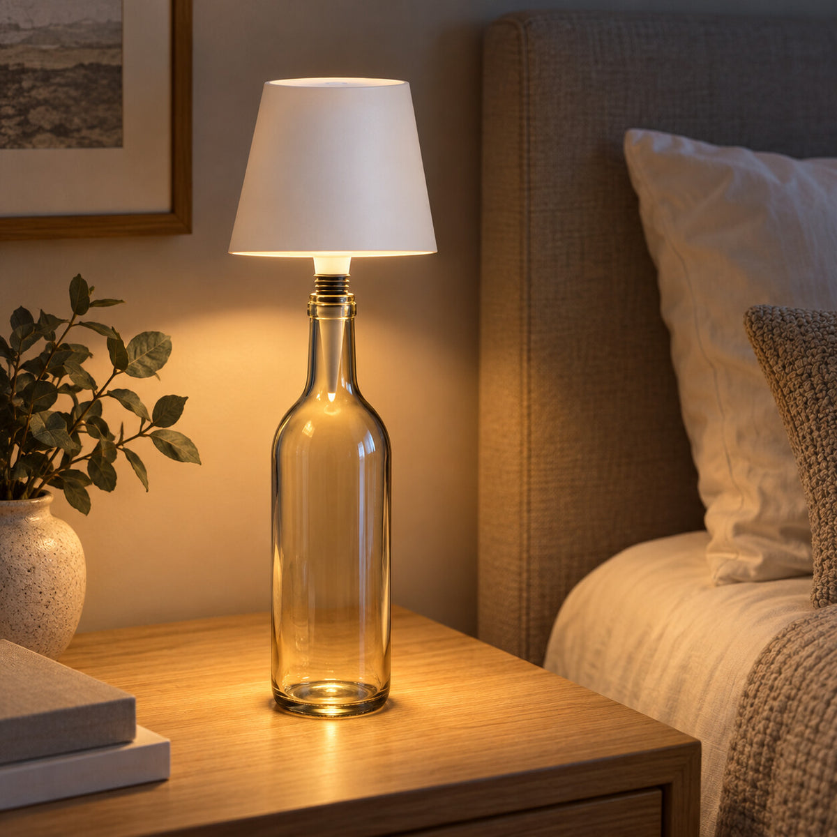 White USB rechargeable bottle lamp glowing on a bedside table