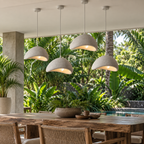 Four gray Wabi-Sabi pendant chandeliers above a tropical terrace dining table